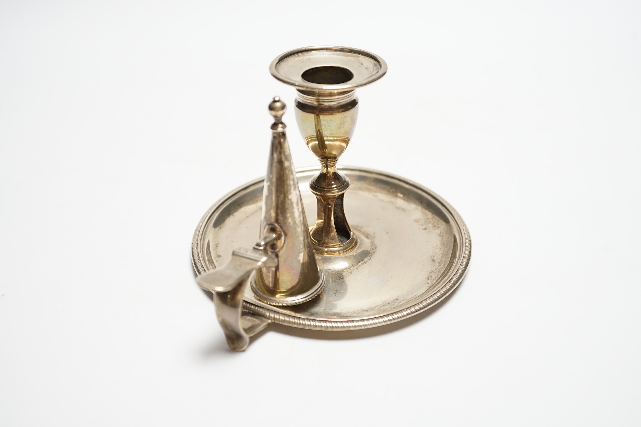 A George III silver chamberstick, John Mewburn, London, 1801, with extinguisher(marks rubbed), diameter 13.7cm, 9.7oz.